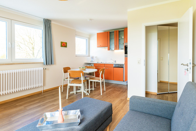 Ferienwohnung in Fehmarn OT Neue Tiefe - Strandhotel Garni Fehmarn - Wohnzimmer mit K&uuml;chenecke und Schlafcouch